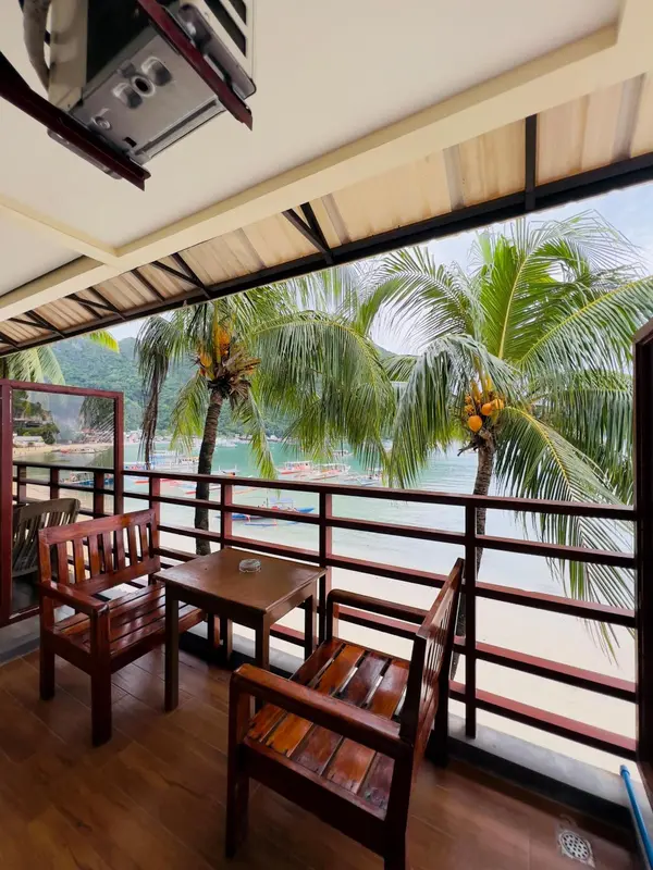 Terrasse en bois avec mobilier donnant sur une baie tropicale.