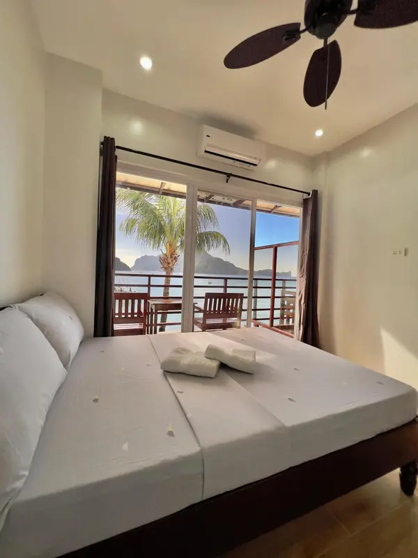 Une chambre lumineuse avec un grand lit donnant sur une vue sur la mer.