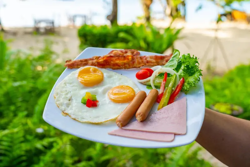 Assiette de petit-déjeuner copieux avec œufs, bacon et saucisses.