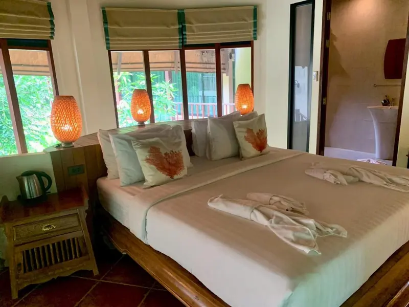 Une chambre lumineuse avec un grand lit et des lampes de chevet.