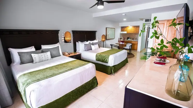 Une chambre lumineuse avec deux lits et un coin repas.
