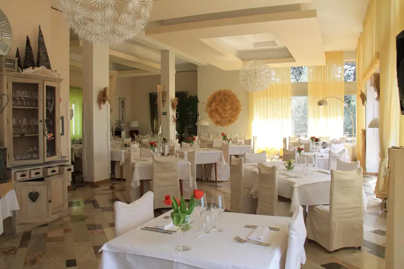 Une salle lumineuse avec des tables dressées pour un repas.