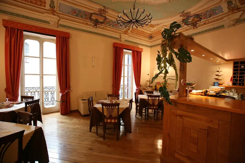 Une salle lumineuse avec des tables et des chaises, un comptoir de buffet et de grandes fenêtres.
