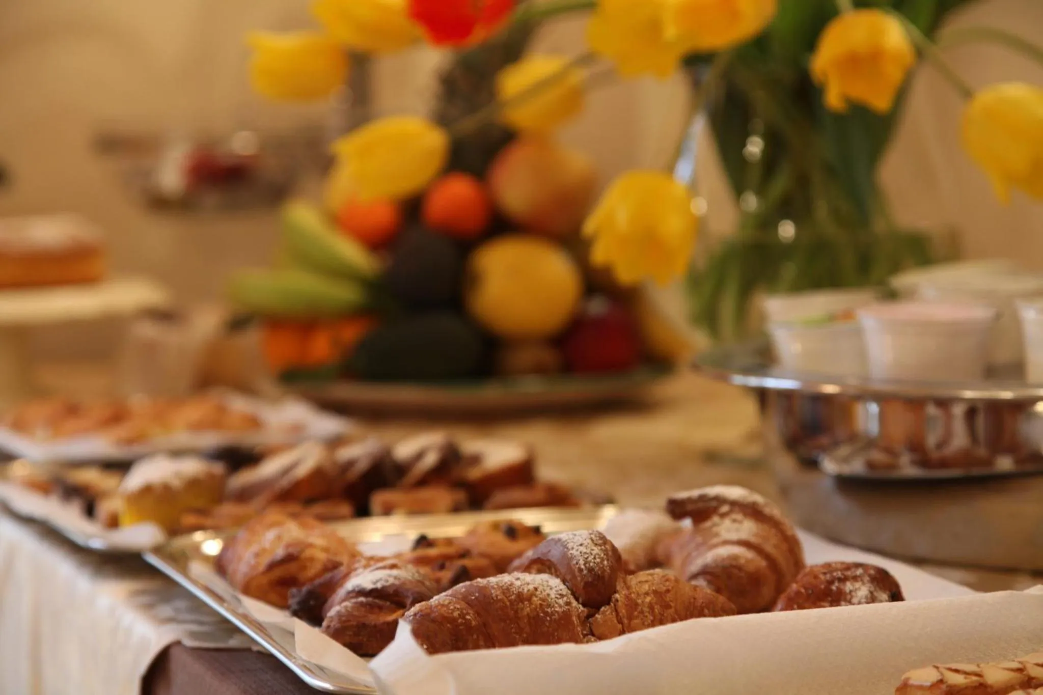 Une table garnie de viennoiseries et de fruits frais.