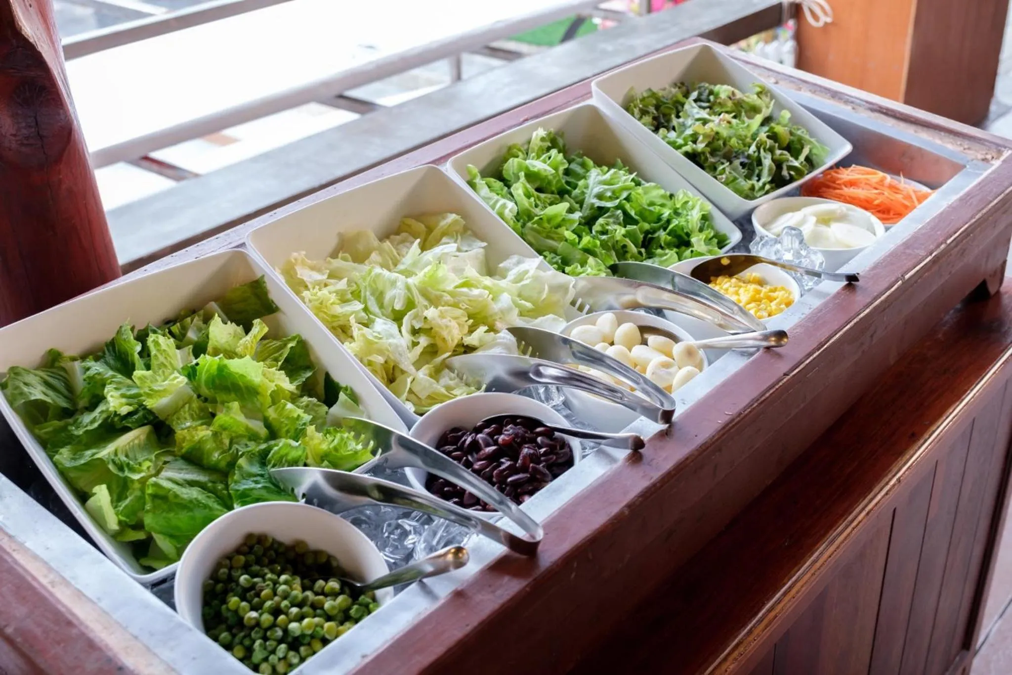Un buffet propose une variété de salades fraîches et de légumes.