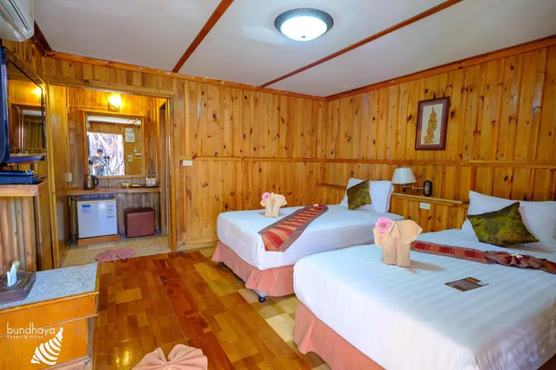 Chambre lumineuse avec deux lits simples et décoration florale.