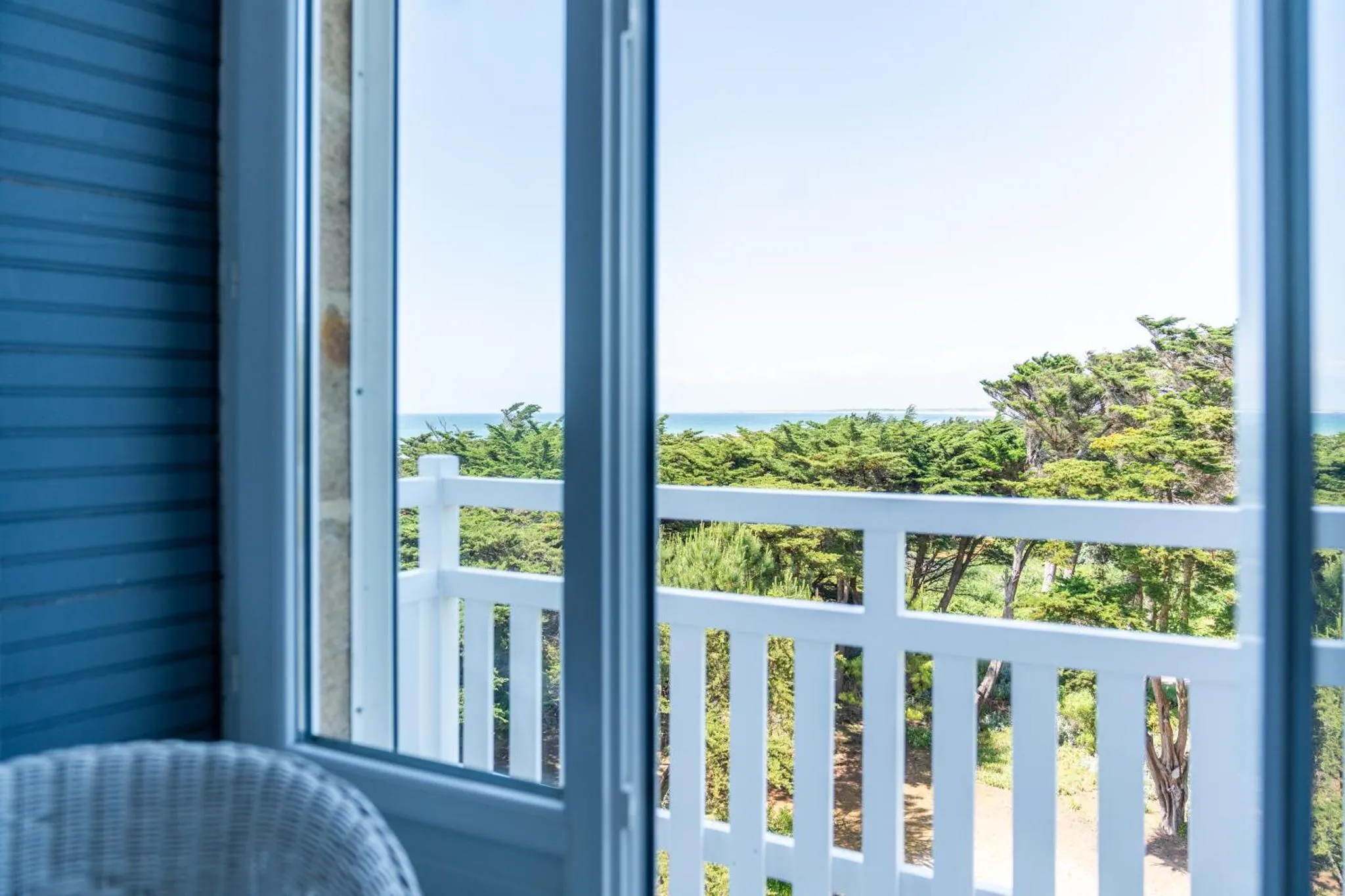 Vue sur la mer depuis un balcon avec garde-corps blanc.