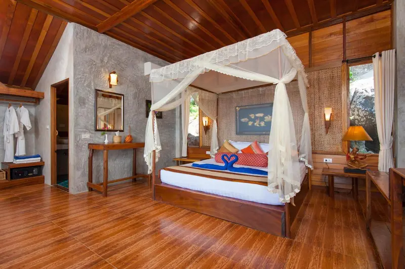 Une chambre lumineuse avec un lit à baldaquin et un parquet en bois.