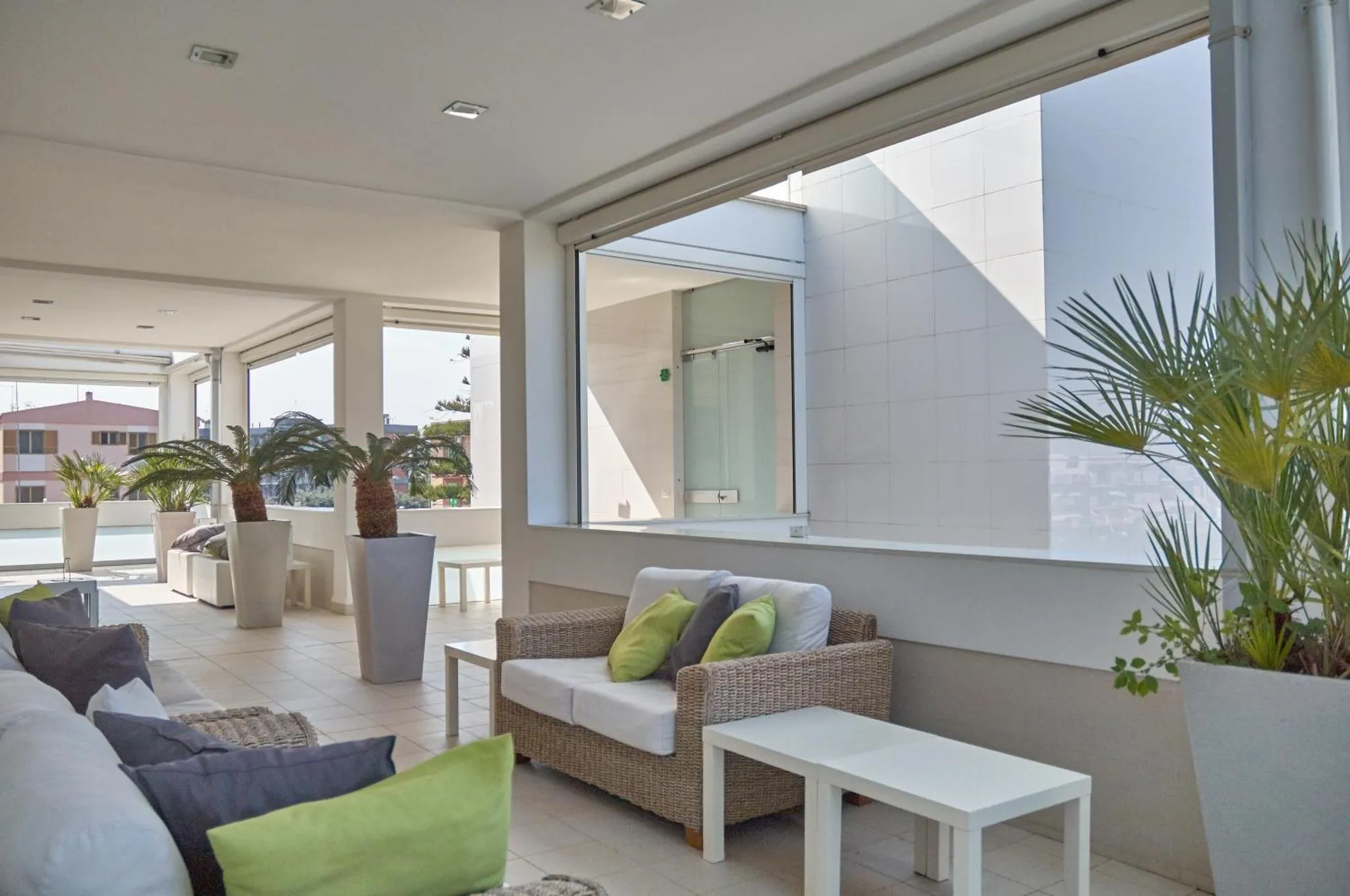 Espace de détente extérieur avec canapés et plantes.