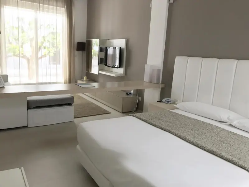 Chambre moderne avec un grand lit et un espace bureau.