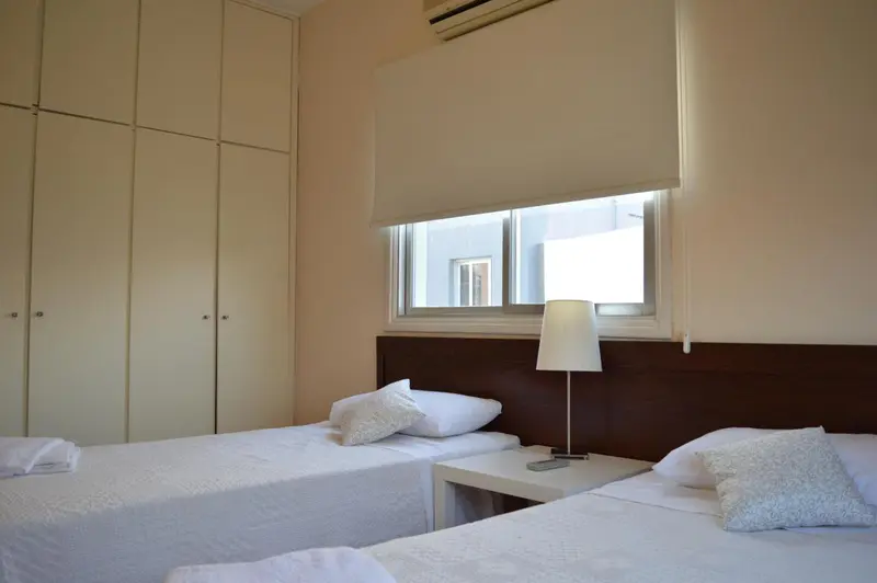 Une chambre lumineuse avec deux lits simples et une fenêtre.