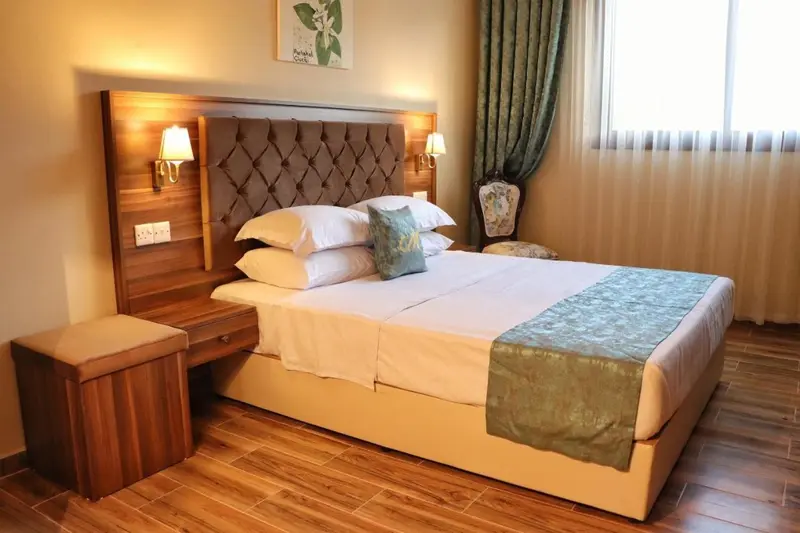 Une chambre avec un grand lit recouvert d'une courtepointe et de coussins.