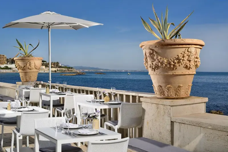 Tables dressées en terrasse avec vue sur la mer.