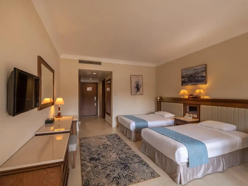 Une chambre lumineuse avec deux lits simples et une décoration sobre.