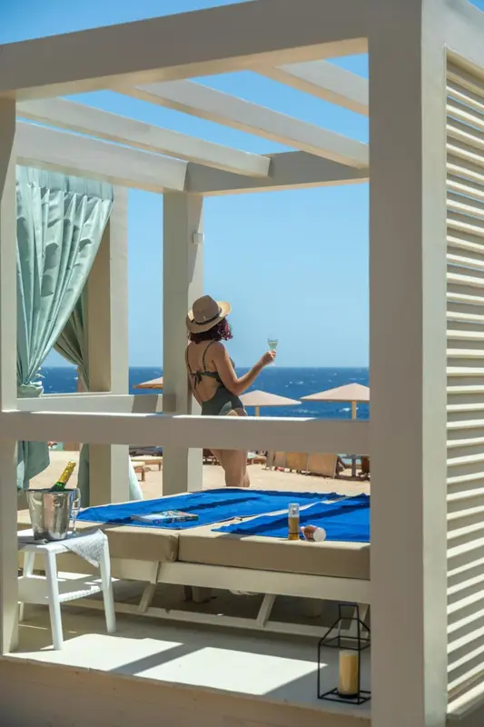 Une personne se détend sur une terrasse avec vue sur la mer.