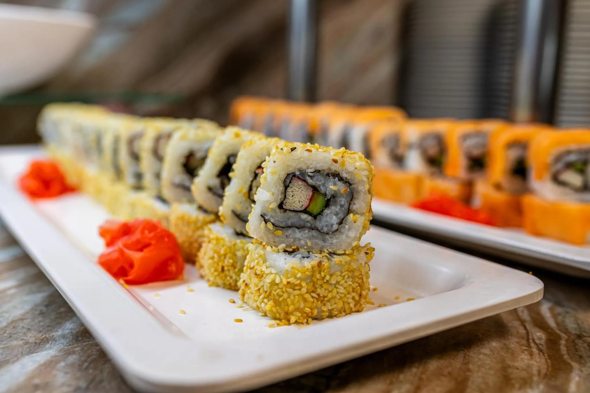 Assortiment de sushis et de makis présentés sur un plat blanc.