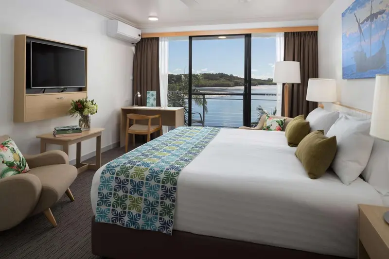 Une chambre lumineuse avec un grand lit et vue sur la mer.