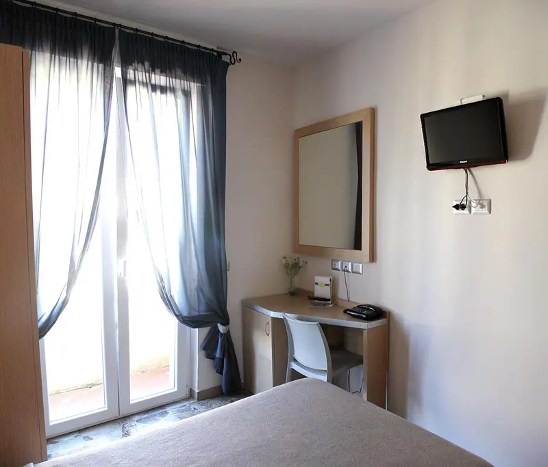 Une chambre lumineuse avec un bureau et une télévision murale.