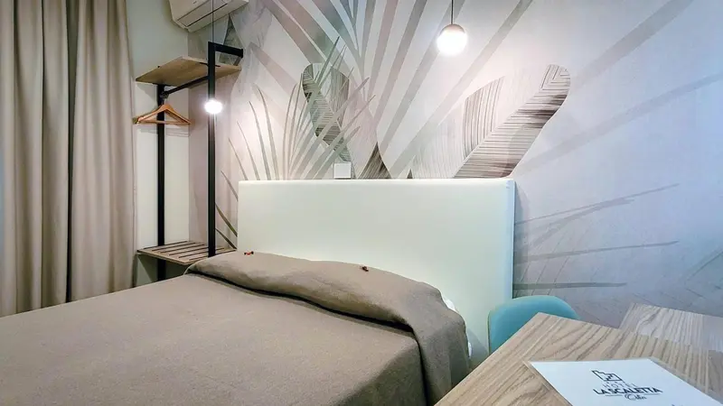 Une chambre lumineuse avec un lit simple et un mur décoratif.