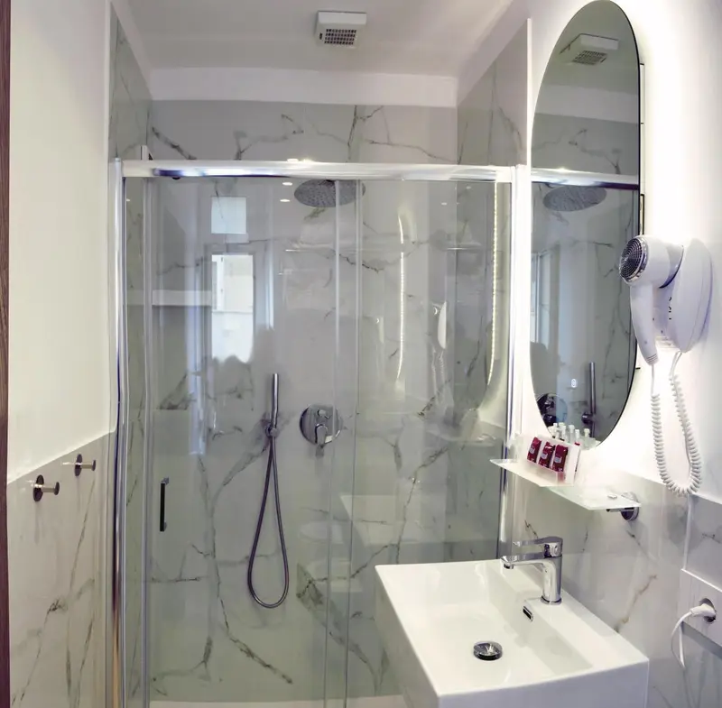 Une salle de bain moderne avec douche à l'italienne et grand miroir.