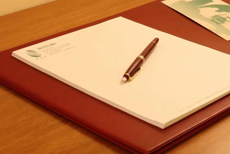 Papier à en-tête d'hôtel et stylo sur une surface en bois.