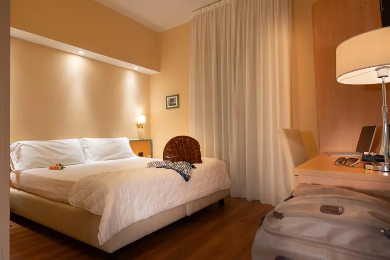 Une chambre lumineuse avec un grand lit et une décoration sobre.