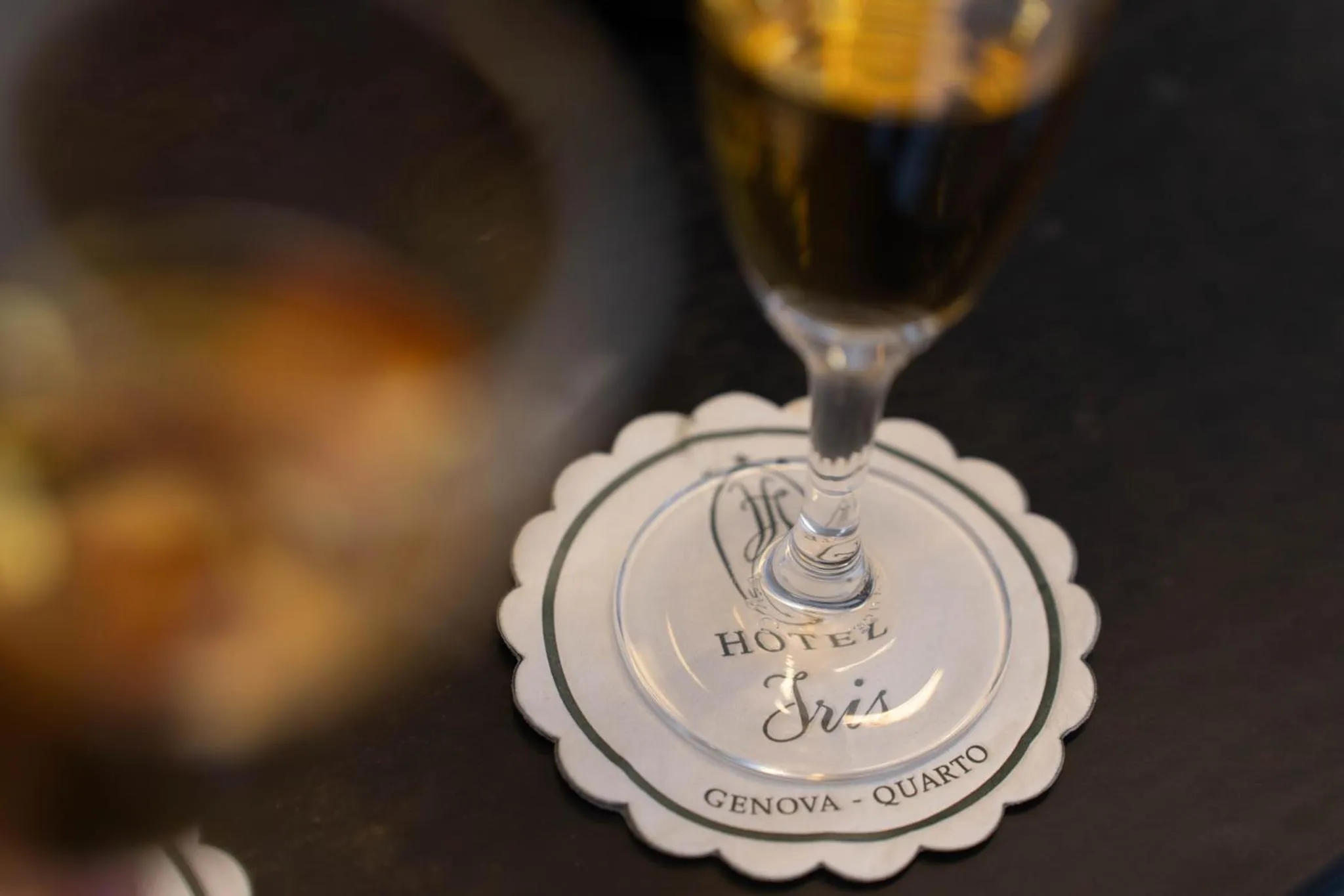 Un verre de boisson posé sur une sous-verre au nom d'un hôtel.