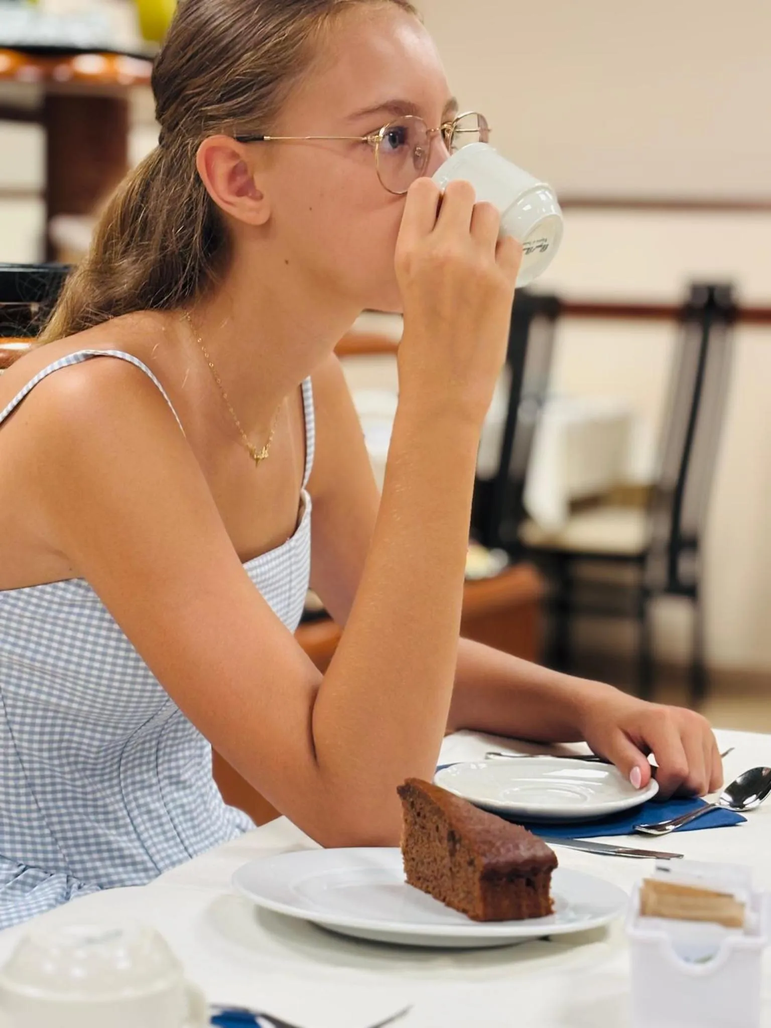 Une personne déguste une boisson et une pâtisserie à table.