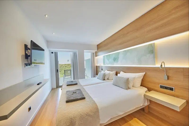 Chambre lumineuse avec un grand lit et une décoration moderne.