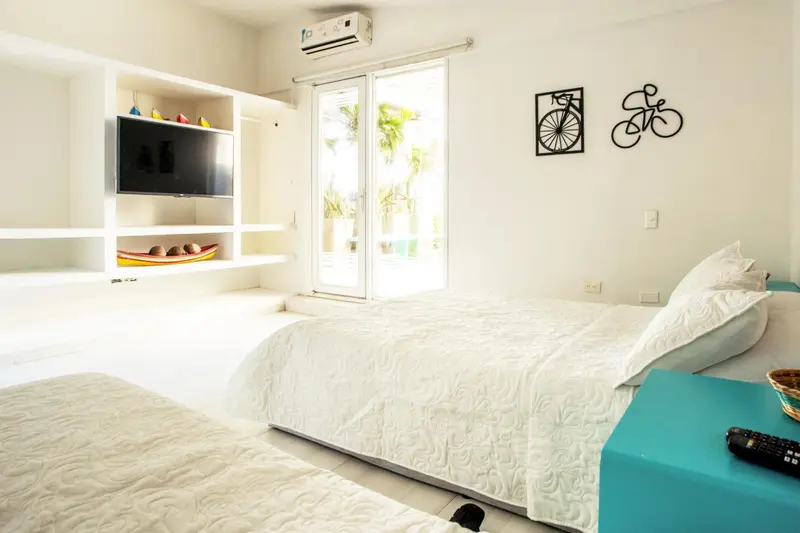 Une chambre lumineuse avec deux lits simples et une vue sur l'extérieur.