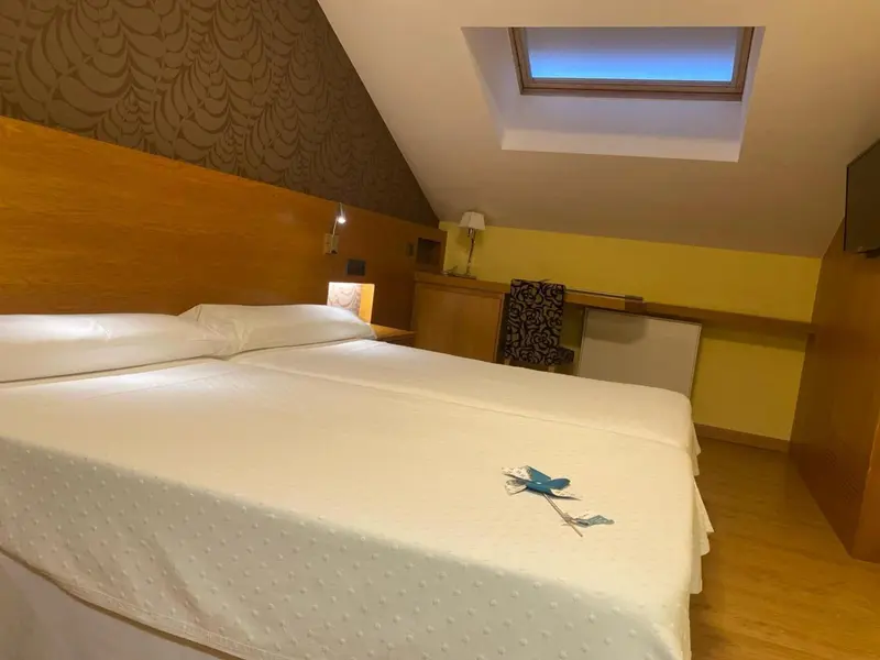 Une chambre lumineuse avec un lit double et des murs colorés.