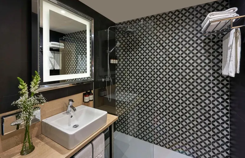 Une salle de bain moderne avec une douche à l'italienne et un lavabo sur un meuble.