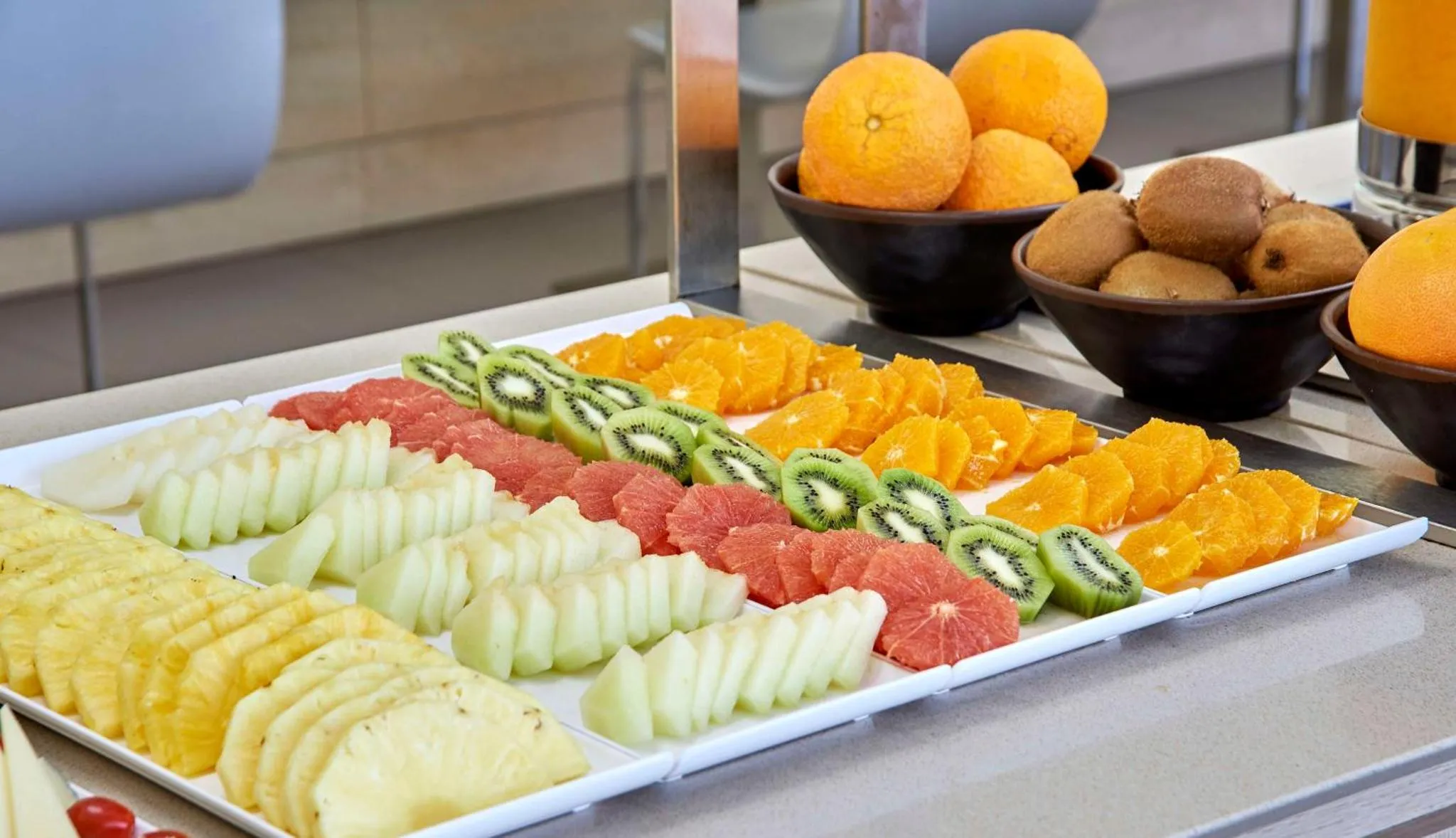 Présentation de fruits frais coupés sur un buffet.