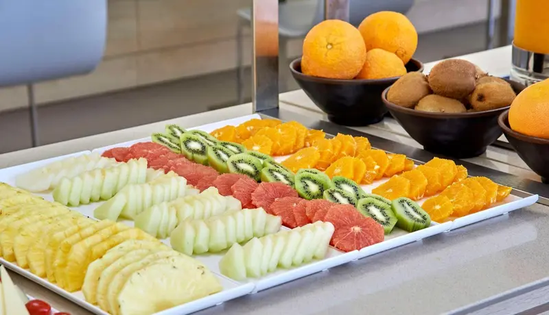 Présentation de fruits frais coupés sur un buffet.