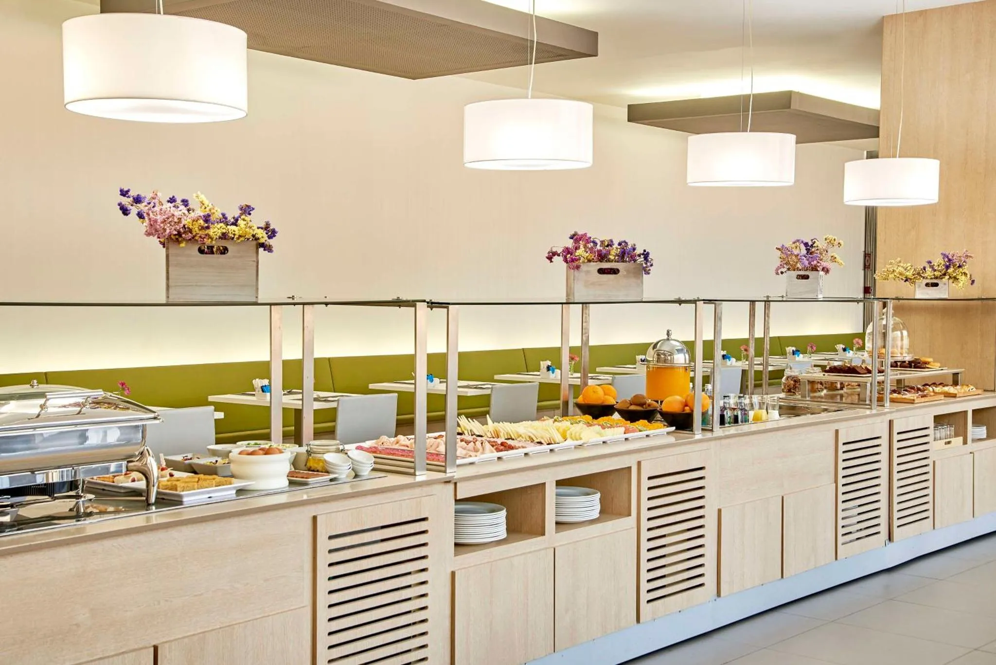 Un buffet propose une variété de plats et de boissons dans une salle lumineuse.