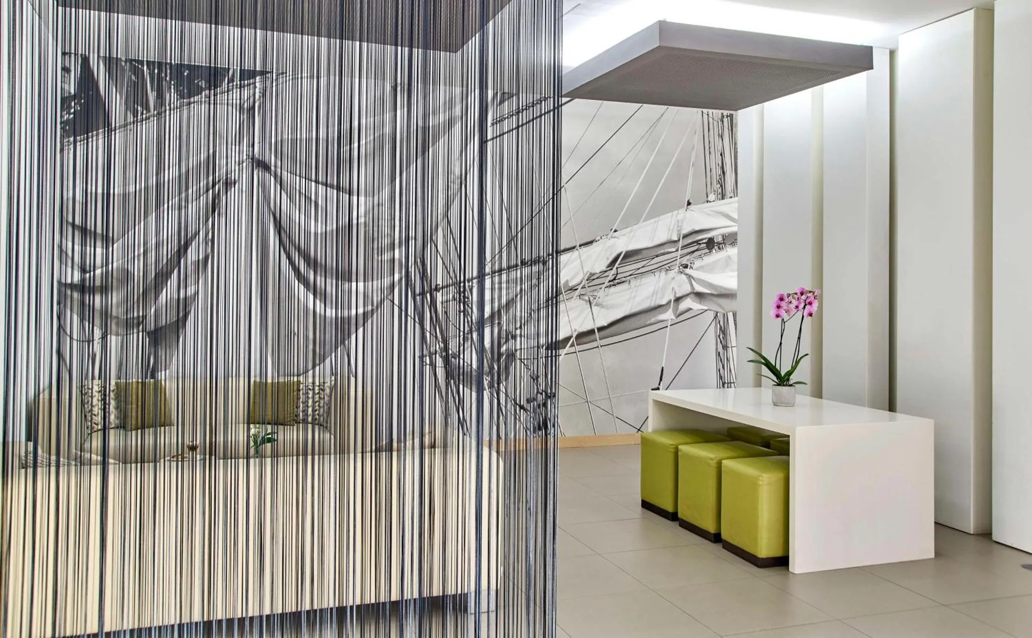 Espace de détente moderne avec canapés verts et rideaux décoratifs.
