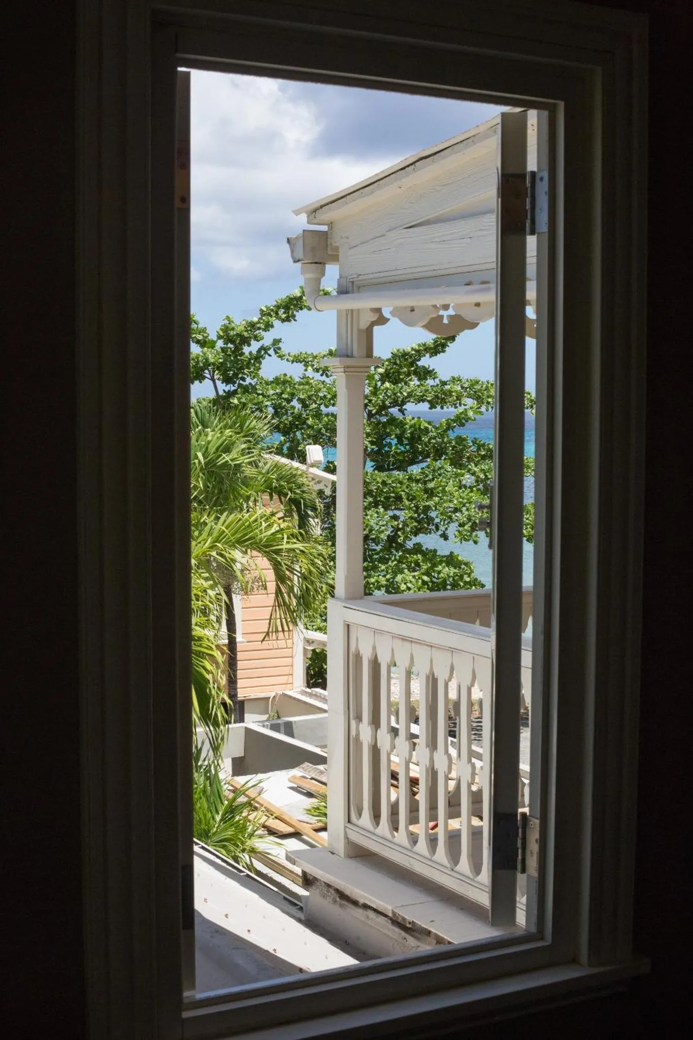 Vue sur la mer depuis une terrasse ombragée.