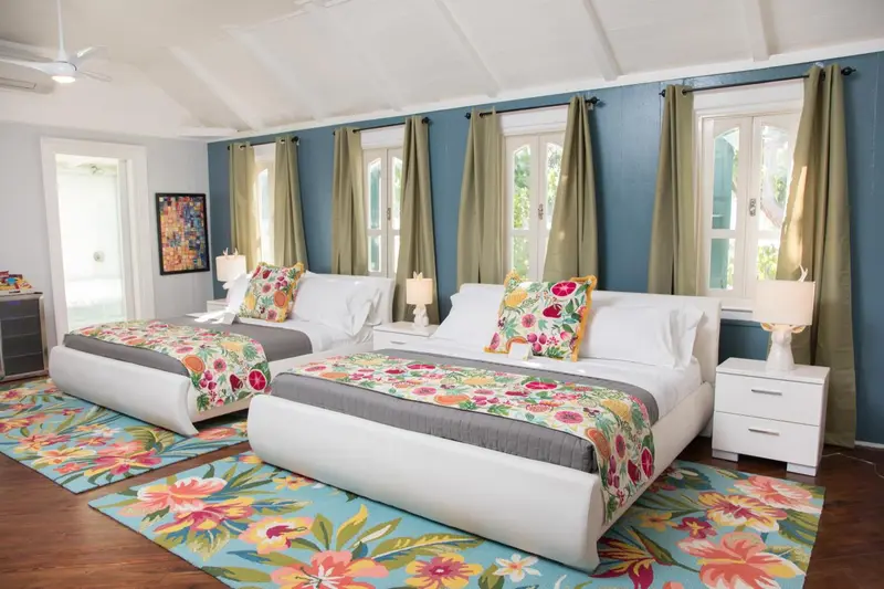 Une chambre lumineuse avec deux lits décorés de motifs floraux.