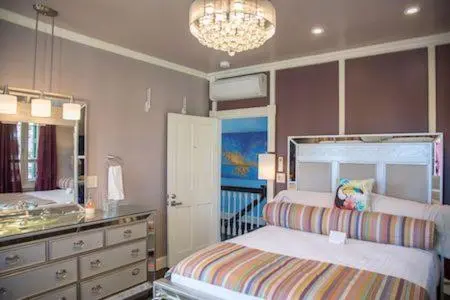 Une chambre à coucher lumineuse avec un grand lit et un lustre décoratif.