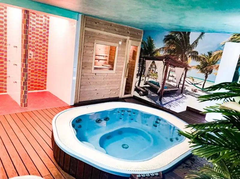 Un jacuzzi extérieur avec une vue sur une plage tropicale.