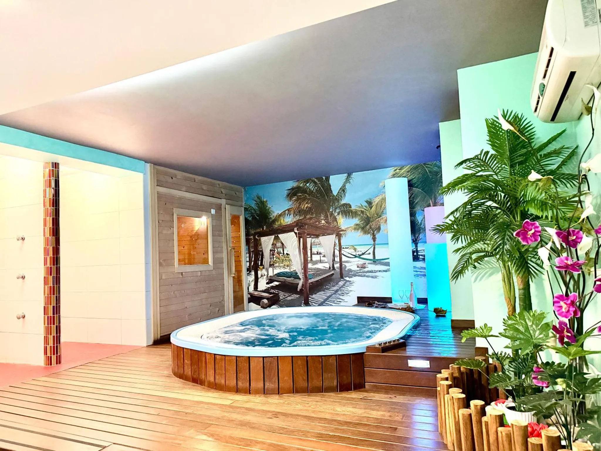 Espace de détente intérieur avec jacuzzi et décoration tropicale.