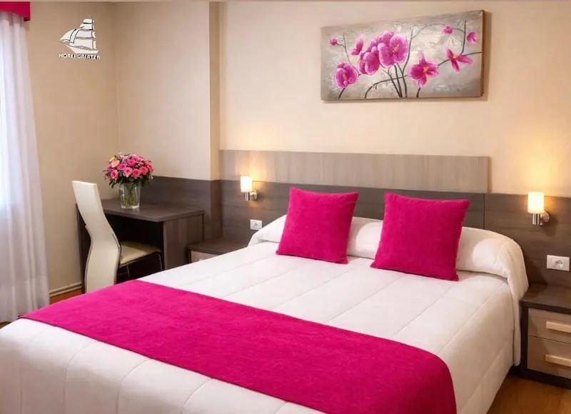 Une chambre d'hôtel lumineuse avec un lit double et un bureau.