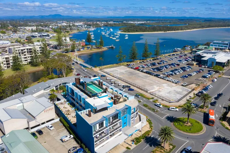 Vue aérienne d'un complexe hôtelier et d'un port de plaisance en bord de mer.