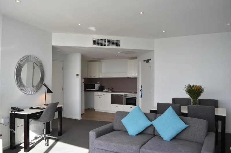 Un espace de vie moderne avec un canapé bleu turquoise et un bureau.