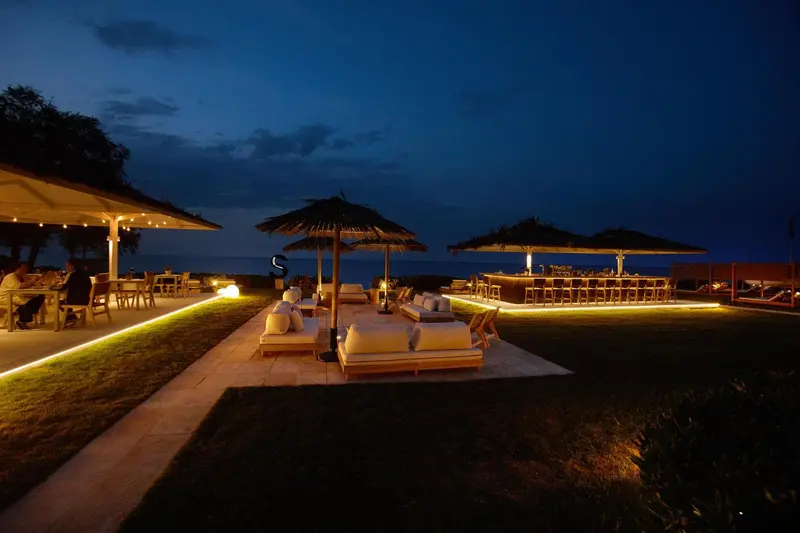 Terrasse lumineuse avec mobilier de détente et espace repas en soirée.