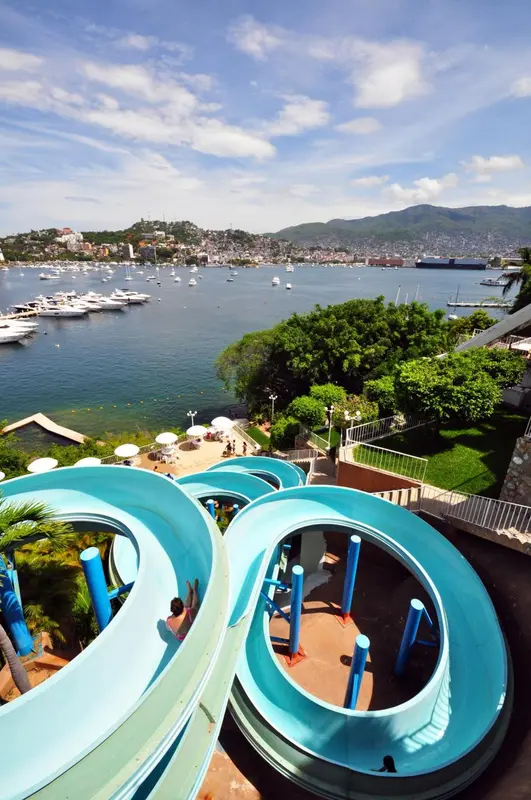 Vue panoramique sur une baie avec des toboggans aquatiques au premier plan.
