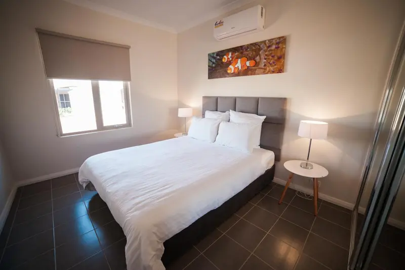 Une chambre lumineuse avec un grand lit recouvert de draps blancs.