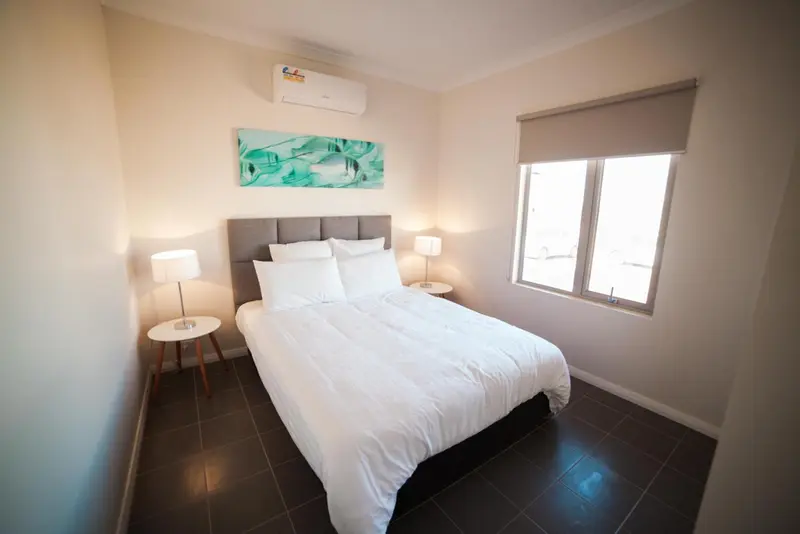 Une chambre lumineuse avec un grand lit recouvert de draps blancs.