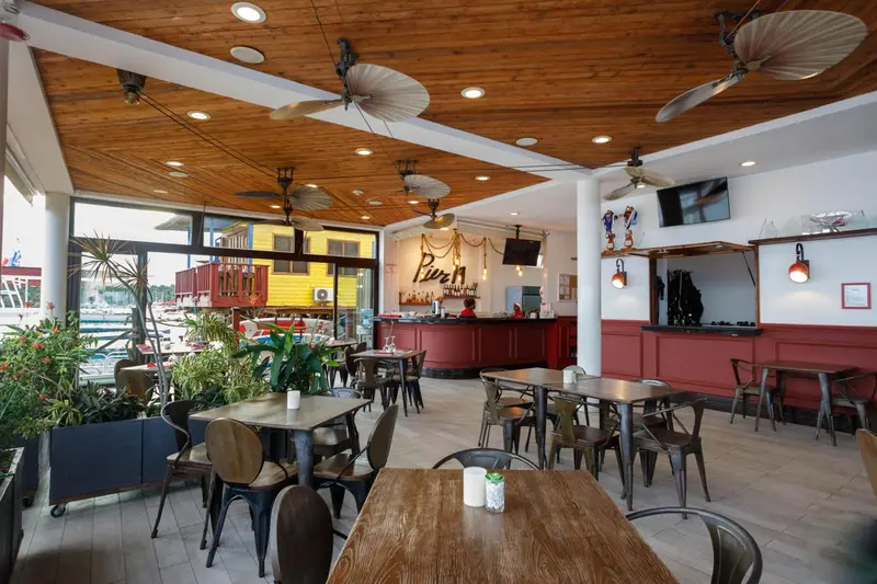Une salle de restaurant lumineuse avec des tables et un comptoir de bar.