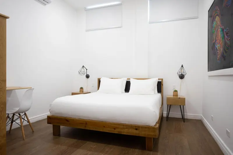 Une chambre lumineuse avec un lit double et un bureau.